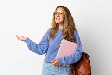 Beyaz arka planda izole edilmiş genç bir bayan davet edilmek için ellerini yana uzatıyor.