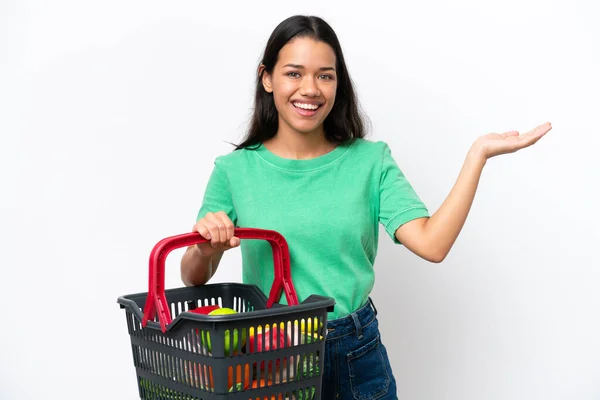 Young Colombian Woman Holding Shopping Basket Full Food Isolated White — Stock fotografie