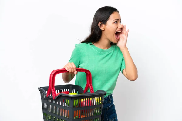 Young Colombian Woman Holding Shopping Basket Full Food Isolated White — Zdjęcie stockowe