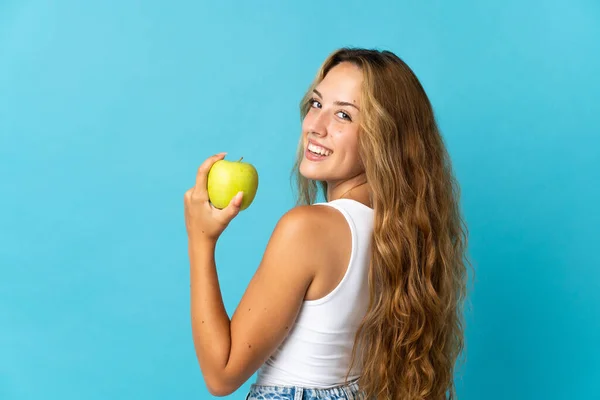 Young Blonde Woman Isolated Blue Background Eating Apple — 图库照片
