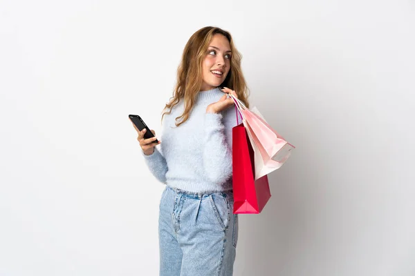 Young Blonde Woman Isolated White Background Holding Shopping Bags Mobile — стоковое фото