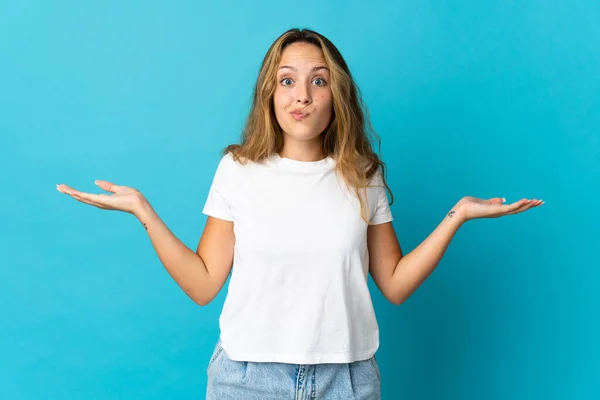 Jong Blond Vrouw Geïsoleerd Blauwe Achtergrond Met Twijfels Terwijl Het — Stockfoto