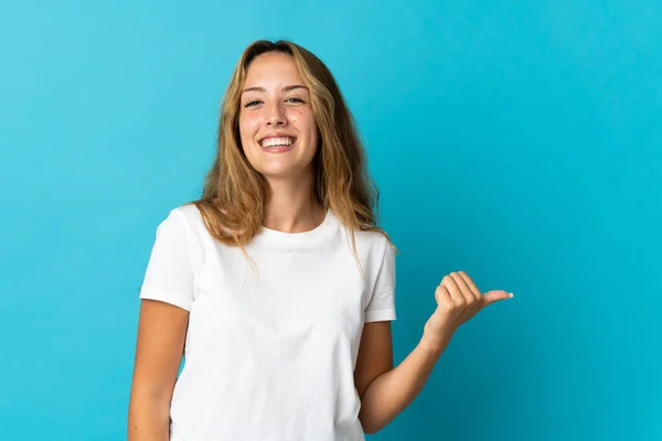 Mujer Rubia Joven Aislada Sobre Fondo Azul Apuntando Hacia Lado —  Fotos de Stock