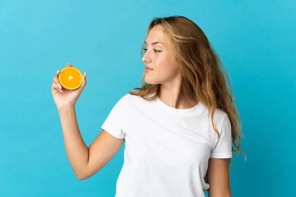 Ung Blond Kvinna Isolerad Blå Bakgrund Håller Orange — Stockfoto
