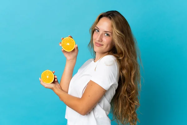 Mladé Blondýny Žena Izolované Modrém Pozadí Drží Oranžovou — Stock fotografie