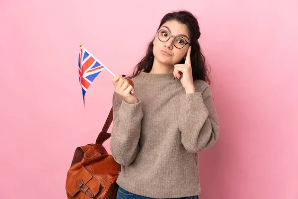 Fiatal Orosz Kezében Egy Brit Zászló Elszigetelt Rózsaszín Háttér Gondolkodás — Stock Fotó