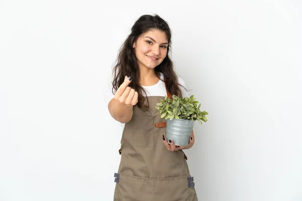 Joven Jardinero Ruso Chica Sosteniendo Una Planta Aislada Haciendo Gesto —  Fotos de Stock