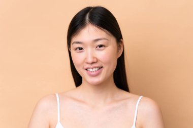 Genç Çinli kadın bej arka planda izole edilmiş. Portre