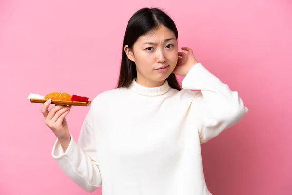 Young Chinese Woman Holding Sashimi Isolated Pink Background Having Doubts — Stockfoto