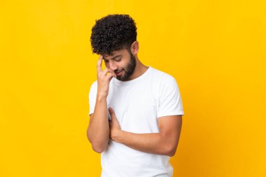 Genç Faslı adam sarı arka planda izole edilmiş gülüyor.