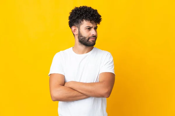 Young Moroccan man isolated on yellow background keeping the arms crossed