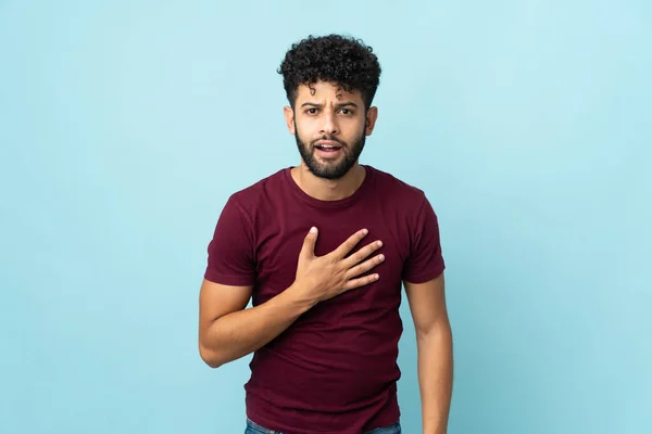 Young Moroccan man isolated on blue background pointing to oneself