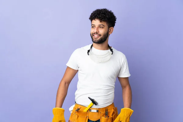 Young Electrician Moroccan Man Isolated Purple Background Posing Arms Hip — Stock Fotó