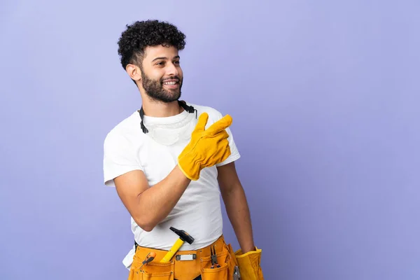 Young Electrician Moroccan Man Isolated Purple Background Pointing Finger Side — Stock Fotó