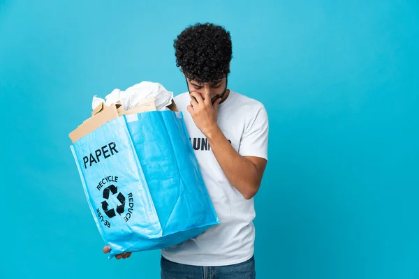 Young Moroccan man holding a recycling bag full of paper to recycle over isolated background laughing