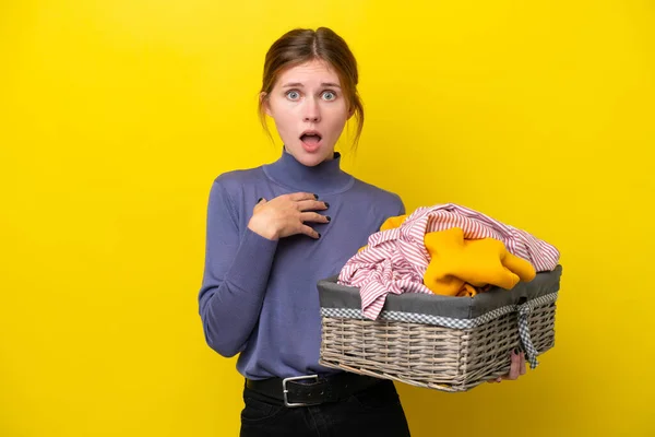 Young English Woman Holding Clothes Basket Isolated Yellow Background Surprised — Stockfoto