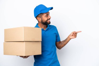 Teslimat yapan Brezilyalı adam beyaz arka planda izole edilmiş bir şekilde parmak göstererek bir ürün sunuyor.