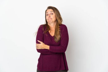 Orta yaşlı Brezilyalı bir kadın beyaz arka planda izole edilmiş. Omuzlarını kaldırırken şüpheli hareketler yapıyor.