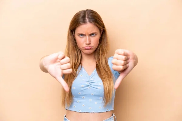 Young Caucasian Woman Isolated Beige Background Showing Thumb Two Hands — Stock Photo, Image