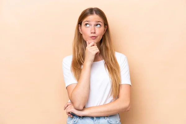 Jovem Mulher Caucasiana Isolado Fundo Bege Olhando Para Cima — Fotografia de Stock