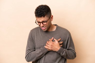 Bej arka planda izole edilmiş genç Brezilyalı adamın kalbinde bir ağrı var.