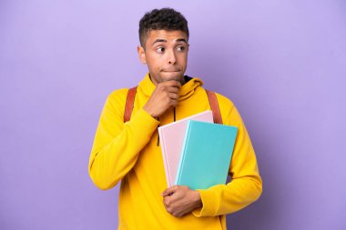 Mor arka planda izole edilmiş Brezilyalı genç bir adamın şüpheleri ve düşünceleri var.