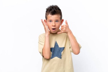 Beyaz arka planda izole edilmiş küçük beyaz çocuk telefon jesti yapıyor ve kuşkulanıyor.