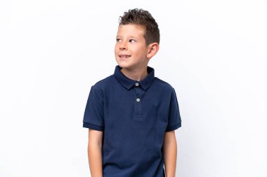 Beyaz arka planda izole edilmiş küçük beyaz çocuk yana bakıyor ve gülümsüyor.