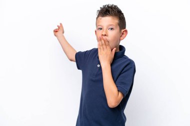 Beyaz arka planda izole edilmiş küçük beyaz çocuk, sürpriz bir ifadeyle işaret ederken...