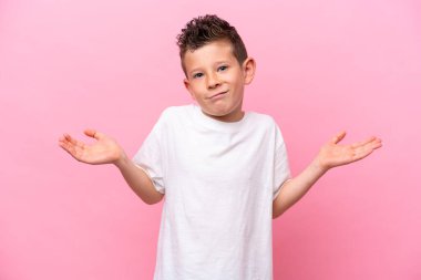 Pembe arka planda izole edilmiş küçük beyaz çocuk ellerini kaldırırken şüpheleri var.