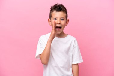 Little caucasian boy isolated on pink background with surprise and shocked facial expression