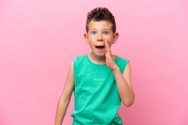 Little caucasian boy isolated on pink background shouting with mouth wide open