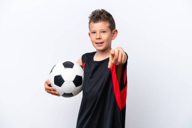 Beyaz arka planda, futbol topuyla izole edilmiş ve ön tarafı işaret eden beyaz bir çocuk.