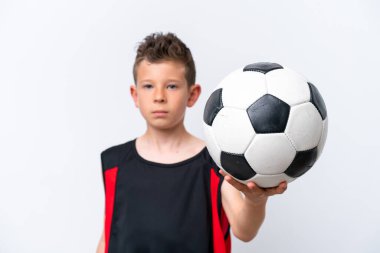 İzole edilmiş beyaz duvarda futbol oynayan çocuk.
