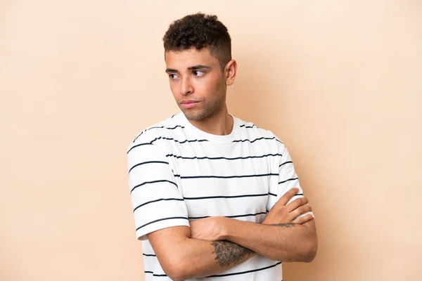 Young Brazilian Man Isolated Beige Background Keeping Arms Crossed — ストック写真