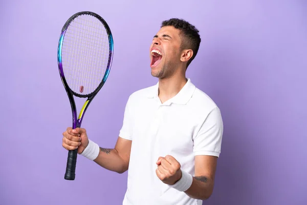 Young Brazilian Man Isolated Purple Background Playing Tennis Celebrating Victory — 스톡 사진