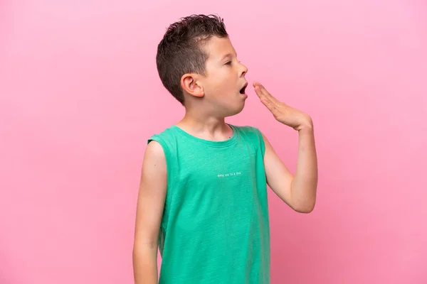 Pequeño Chico Caucásico Aislado Sobre Fondo Rosa Bostezando Cubriendo Boca —  Fotos de Stock