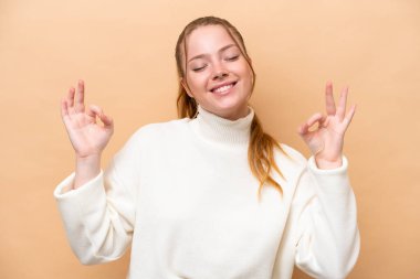 Zen pozunda bej arka planda izole edilmiş beyaz bir kadın.