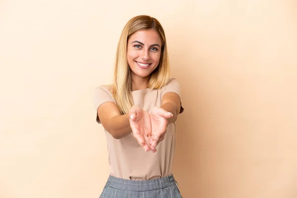 Blonde Uruguayan Girl Isolated Beige Background Holding Copyspace Imaginary Palm — Stockfoto