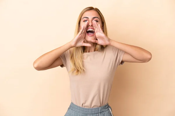 Blonde Uruguayan Girl Isolated Beige Background Shouting Announcing Something — Stock fotografie