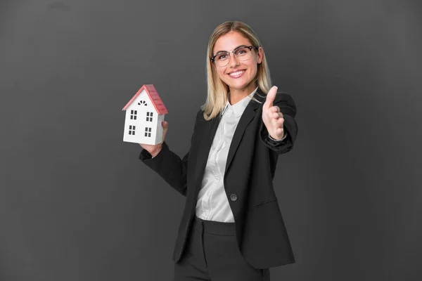 Blonde Uruguayan Girl Holding House Toy Isolated Black Background Shaking — Stockfoto