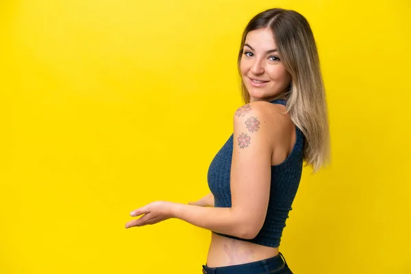 Young Rumanian Woman Isolated Yellow Background Extending Hands Side Inviting — 스톡 사진