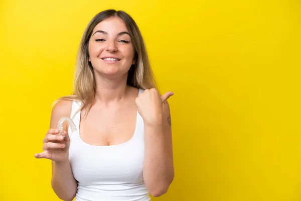 Young Rumanian Woman Holding Envisaging Isolated Yellow Background Pointing Side — 图库照片