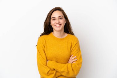Beyaz arka planda izole edilmiş genç beyaz kadın kollarını ön cephede çapraz tutuyor.