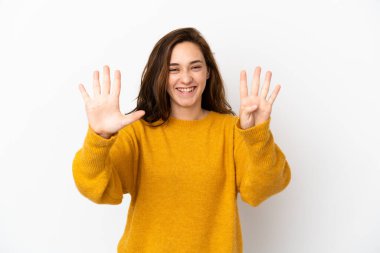 Beyaz arka planda izole edilmiş beyaz tenli genç kadın parmaklarıyla dokuz kişi sayıyor.