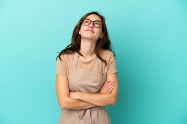 Restoran garsonu gülümserken yukarı bakıyor.