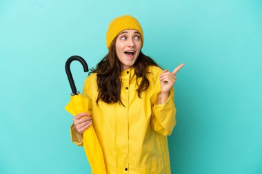 Mavi arka planda şemsiye tutan beyaz bir adam çözümü fark etmek için parmağını kaldırıyor.