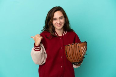 Beyzbol oynayan beyaz bir kadın mavi arka planda izole edilmiş bir şekilde bir ürünü sunmak için yan tarafa bakıyor.