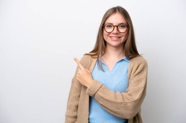 Beyaz arka planda izole edilmiş genç Litvanyalı kadın bir ürünü sunmak için kenarı işaret ediyor