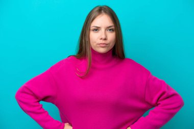 Genç Litvanyalı kadın mavi arka planda izole edilmiş kızgın.